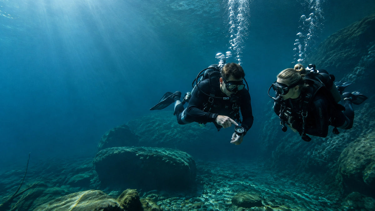 Zwei Taucher erkunden einen klaren See und üben Navigation und Tarierung