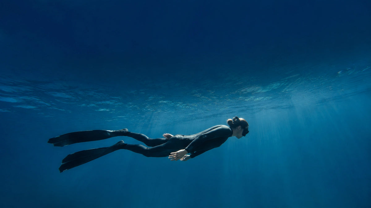 Ein entspannter Freediver gleitet knapp unter der Wasseroberfläche