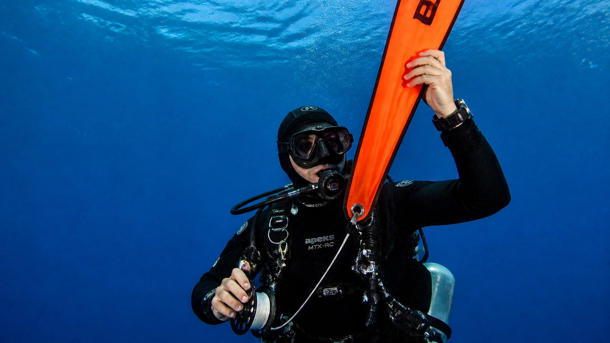 Taucher setzt eine Signalboje (SMB) mit Spool unter Wasser