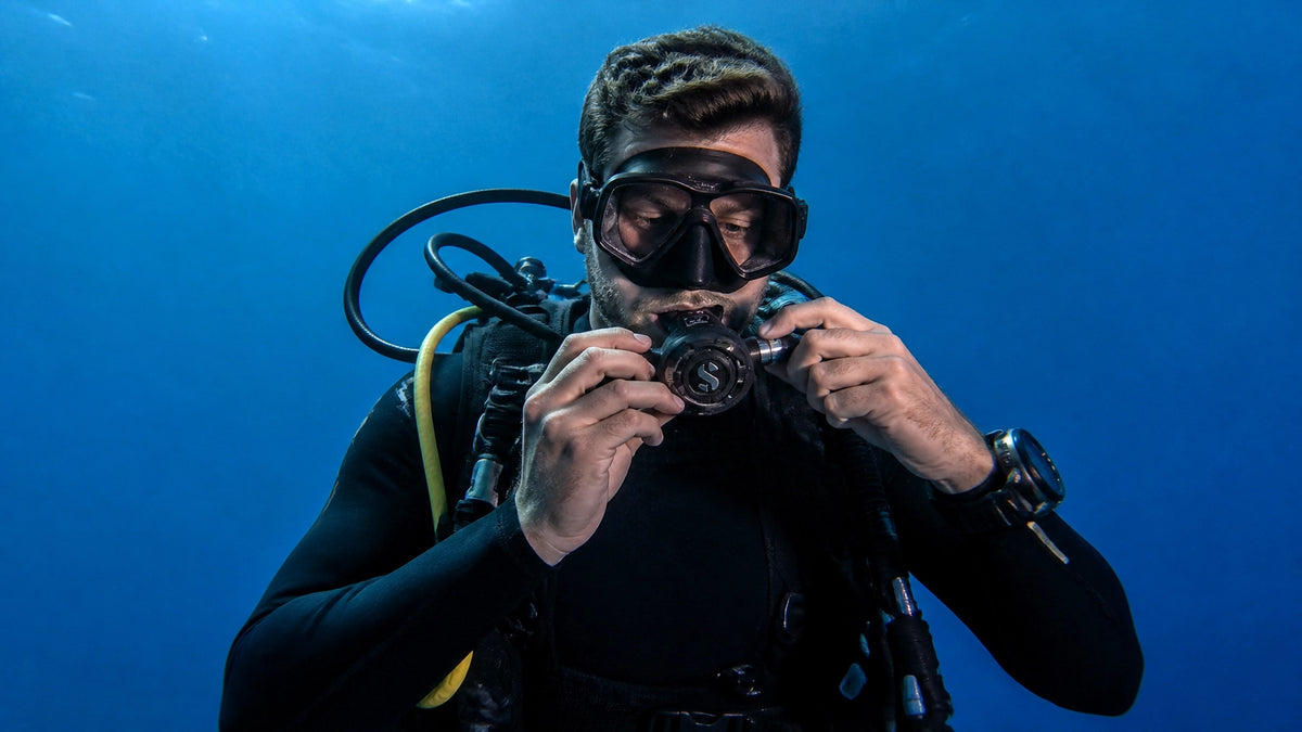 Diver adjusting second stage regulator underwater